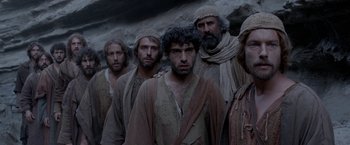 Movie still from “Risen” (2016), directed by Kevin Reynolds – A group of men standing next to each other; Medium shot, Low angle