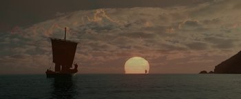 Movie still from “Risen” (2016), directed by Kevin Reynolds – The sun is setting over the ocean with a boat in the foreground; Extreme Wide shot, Low angle