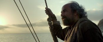 A man with a long beard holding onto a rope