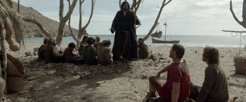 Movie still from “Risen” (2016), directed by Kevin Reynolds – A group of people sitting on the beach; Wide shot, Low angle