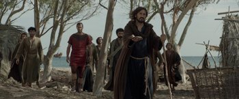 Movie still from “Risen” (2016), directed by Kevin Reynolds – A group of men walking through a forest; Wide shot, Low angle