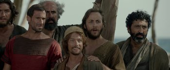 Movie still from “Risen” (2016), directed by Kevin Reynolds – A group of men standing next to each other on a field; Medium shot, Low angle