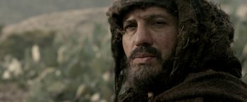 Movie still from “Risen” (2016), directed by Kevin Reynolds – A man with a beard wearing a fur hat; Close Up shot, Low angle