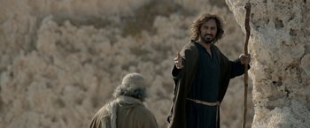 Movie still from “Risen” (2016), directed by Kevin Reynolds – A man with a long beard is pointing at a man with long hair; Medium shot, Over the shoulder angle
