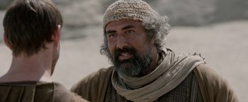 Movie still from “Risen” (2016), directed by Kevin Reynolds – A man with a beard wearing a hat and a scarf; Close Up shot, Over the shoulder angle