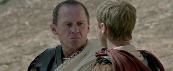 Movie still from “Risen” (2016), directed by Kevin Reynolds – A man in a roman outfit looking at another man in a roman outfit; Close Up shot, Over the shoulder angle