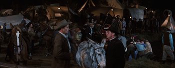Movie still from “River of No Return” (1954), directed by Otto Preminger – Two men are standing next to a donkey; Medium shot, Over the shoulder angle