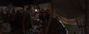 Movie still from “River of No Return” (1954), directed by Otto Preminger – A man and a boy sitting on a horse in the dark; Medium shot, Over the shoulder angle