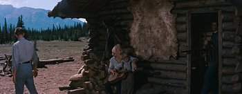 Movie still from “River of No Return” (1954), directed by Otto Preminger – A woman and a child playing a guitar; Wide shot, Low angle