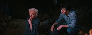 Movie still from “River of No Return” (1954), directed by Otto Preminger – A man and a woman sitting next to each other on the ground; Medium shot, Over the shoulder angle