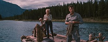 Movie still from “River of No Return” (1954), directed by Otto Preminger – A woman and two men standing on a dock; Wide shot, Low angle
