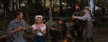 Movie still from “River of No Return” (1954), directed by Otto Preminger – A man and a woman in the woods with a knife in their hand; Medium shot, Over the shoulder angle