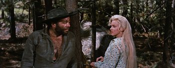 Movie still from “River of No Return” (1954), directed by Otto Preminger – A man and a woman sitting next to each other in the woods; Medium shot, Over the shoulder angle