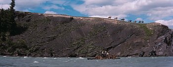 Movie still from “River of No Return” (1954), directed by Otto Preminger – A group of people on a raft in the water; Extreme Wide shot, High angle