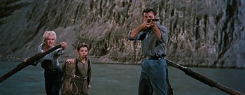 Movie still from “River of No Return” (1954), directed by Otto Preminger – A man taking a picture of a young boy with a camera; Medium shot, Low angle
