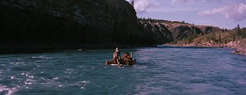 Movie still from “River of No Return” (1954), directed by Otto Preminger – A man on a raft in the middle of a river; Extreme Wide shot, High angle