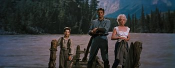 Movie still from “River of No Return” (1954), directed by Otto Preminger – A group of people standing next to each other near trees; Wide shot, Low angle