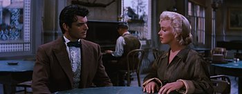 Movie still from “River of No Return” (1954), directed by Otto Preminger – A man and a woman sitting at a table in front of a piano; Medium shot, Over the shoulder angle