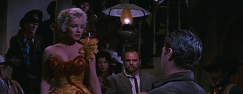 Movie still from “River of No Return” (1954), directed by Otto Preminger – A group of people standing in a room with a lamp; Medium shot, Over the shoulder angle