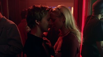 A man and a woman are kissing in a room