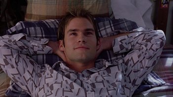 Movie still from “Road Trip” (2000), directed by Todd Phillips – A man laying in bed with his hands behind his head; Close Up shot, Overhead angle
