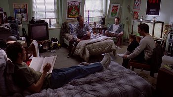 Movie still from “Road Trip” (2000), directed by Todd Phillips – A group of people sitting on a bed in a room; Wide shot, High angle