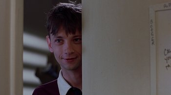 Movie still from “Road Trip” (2000), directed by Todd Phillips – A young man in a maroon shirt and a black tie; Close Up shot, Over the shoulder angle