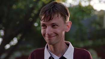 Movie still from “Road Trip” (2000), directed by Todd Phillips – A person smiling with trees in the background; Close Up shot, Low angle