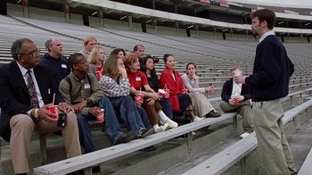 Movie still from “Road Trip” (2000), directed by Todd Phillips – A group of people sitting in bleachers at a sporting event; Wide shot, High angle
