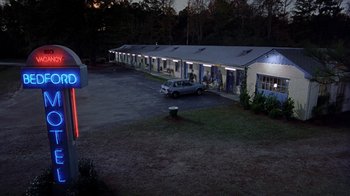Movie still from “Road Trip” (2000), directed by Todd Phillips – A car is parked in front of a motel room at night; Extreme Wide shot, High angle