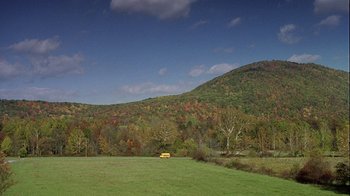 Movie still from “Road Trip” (2000), directed by Todd Phillips – A yellow school bus parked in the middle of a green field; Extreme Wide shot, High angle