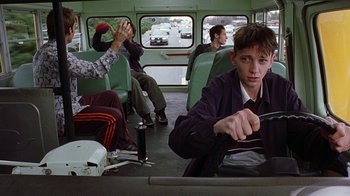 Movie still from “Road Trip” (2000), directed by Todd Phillips – A group of people sitting on a bus; Medium shot, Low angle