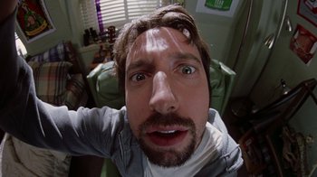Movie still from “Road Trip” (2000), directed by Todd Phillips – A person taking a selfie in a living room; Extreme Close Up shot, Overhead angle
