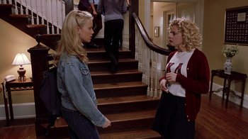 Movie still from “Road Trip” (2000), directed by Todd Phillips – Two women standing in front of each other in front of a staircase; Medium shot, High angle