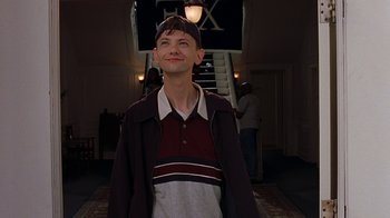 Movie still from “Road Trip” (2000), directed by Todd Phillips – A man standing in front of a stair case; Medium shot, Low angle