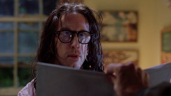 Movie still from “Road Trip” (2000), directed by Todd Phillips – A man with long hair and glasses looking at a laptop; Close Up shot, Low angle