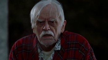 Movie still from “Road Trip” (2000), directed by Todd Phillips – An older man with white hair wearing a plaid shirt; Close Up shot, Low angle