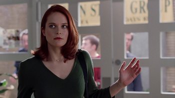 Movie still from “Road Trip” (2000), directed by Todd Phillips – A red headed woman in a green shirt holding her hand up to her face; Close Up shot, Over the shoulder angle