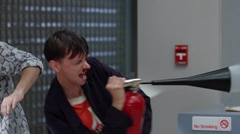 Movie still from “Road Trip” (2000), directed by Todd Phillips – A woman holding a fire extinguisher in her hands; Close Up shot, Over the shoulder angle
