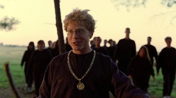 Movie still from “Road Trip” (2000), directed by Todd Phillips – A man wearing a gold chain around his neck; Medium shot, Over the shoulder angle