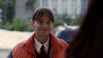 Movie still from “Road Trip” (2000), directed by Todd Phillips – A man in an orange jacket smiling for the camera; Close Up shot, Over the shoulder angle