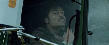 Movie still from “Road Games” (1981), directed by Richard Franklin – A man sitting in a car with his hands clasped together; Close Up shot, Low angle