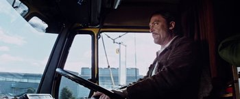 Movie still from “Road Games” (1981), directed by Richard Franklin – A man sitting in the driver's seat of a bus; Medium shot, Low angle