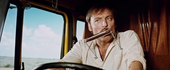 Movie still from “Road Games” (1981), directed by Richard Franklin – A man sitting in the driver's seat of a truck; Close Up shot, Low angle