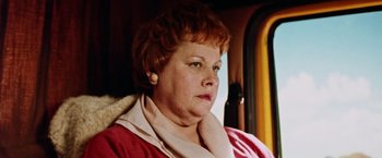 Movie still from “Road Games” (1981), directed by Richard Franklin – An older woman sitting in a car looking off to the side; Close Up shot, Low angle