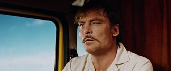 Movie still from “Road Games” (1981), directed by Richard Franklin – A person with a mustache in a vehicle; Close Up shot, Low angle