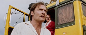 Movie still from “Road Games” (1981), directed by Richard Franklin – A man and a woman looking out of the window of a bus; Close Up shot, Low angle
