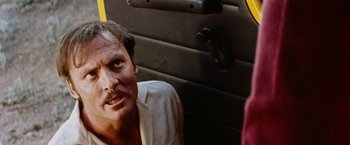 Movie still from “Road Games” (1981), directed by Richard Franklin – A person sitting in front of a wall; Close Up shot, Low angle