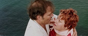 Movie still from “Road Games” (1981), directed by Richard Franklin – A man and a woman kissing in front of a body of water; Close Up shot, High angle