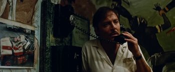 Movie still from “Road Games” (1981), directed by Richard Franklin – A man talking on a phone while sitting in a room; Close Up shot, Low angle